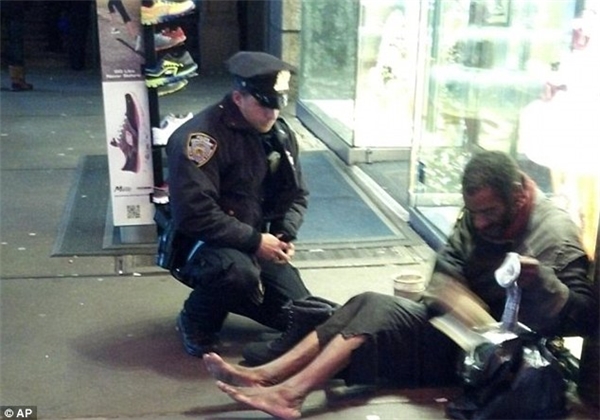 Bức ảnh được một du khách vô tình chụp được trên đường phố. Trong ảnh, một nhân viên cảnh sát đang tặng cho người đàn ông vô gia cư này một đôi giày và tất giữa đêm đông lạnh giá.