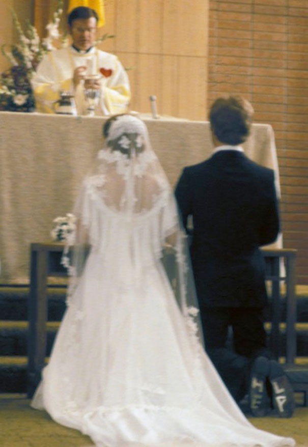 Một cặp đôi đang làm lễ cưới trong nhà thờ, chỉ cần nhìn sau lưng thôi là cũng biết họ trông hạnh phúc thế nào.