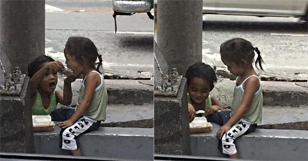 Trên chấn song bê tông, cô em gái ngồi yên cho anh trai đút từng muỗng thức ăn. (Ảnh: Internet)