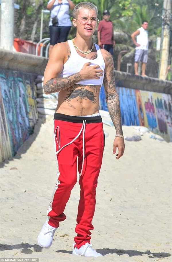 Justin Bieber với mái đầu húi cua nhuộm bạch kim, áo trắng ngắn trên bãi biển Brazil hồi tháng 3.