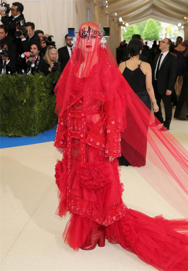 Katy Perry cũng không hề kém cạnh khi diện bộ trang phục đỏ chóe, được ví von như thánh cô lên đồng. Tổng thể là sự kết hợp của nhiều loại trang phục mang những phong cách khác nhau. Đây là thiết kế của Maison Margiela.
