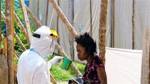 Một nhân viên y tế cho một phụ nữ nhiễm Ebola uống nước tại Kenema, Sierra Leone.