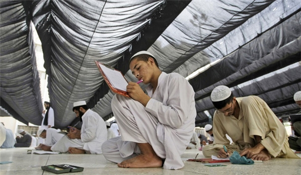 Ở Karachi, Pakistan, các học sinh phải ngồi trên sàn để làm bài thi tại trường Hồi giáo, Jamia Binoria. Các bạn Việt Nam có muốn thử kỳ thi vừa căng não vừa "đau lưng" như vậy không nào. (Ảnh: Internet)