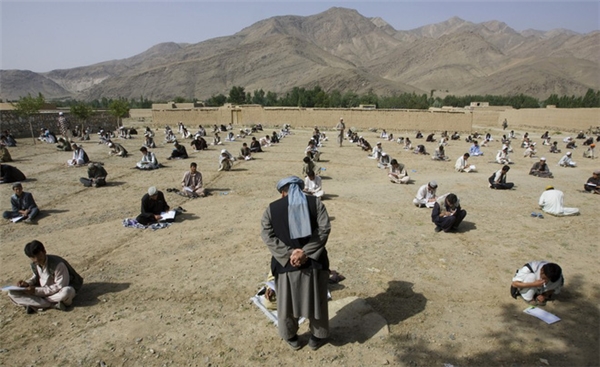 Các học sinh phải ngồi trên đất dưới trời nắng nóng trong một kỳ thi cuối năm tại một trường học ở làng Sangarkhel, thuộc tỉnh Wardak, Afghanistan. (Ảnh: Internet)