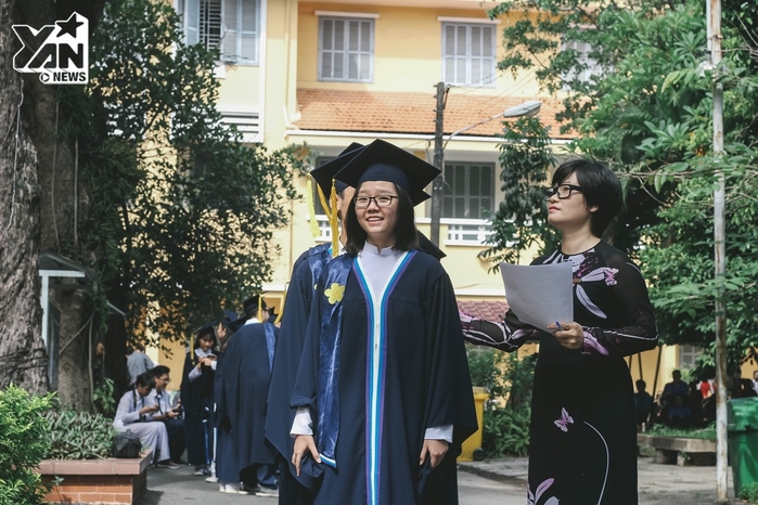 
Chiếc áo choàng màu xanh đậm, có phần tay rộng và đính hoa mai vàng - logo đặc trưng của ngôi trường ba thế hệ Áo Tím - Gia Long - Minh Khai.