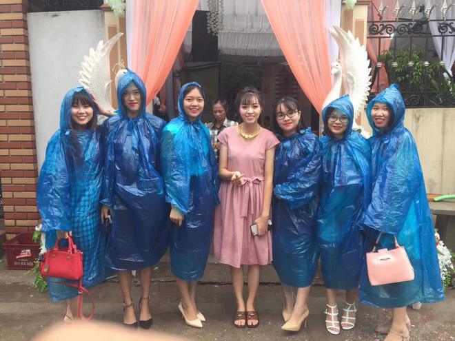 
 Các cô gái diện đồng phục áo mưa xanh đi ăn cưới bất chấp thời tiết mưa bão