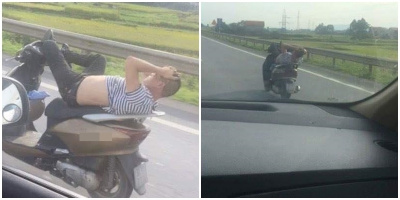 Nam thanh niên đầu trần, vừa nằm gối tay sau đầu vừa lái xe máy lao vun vút