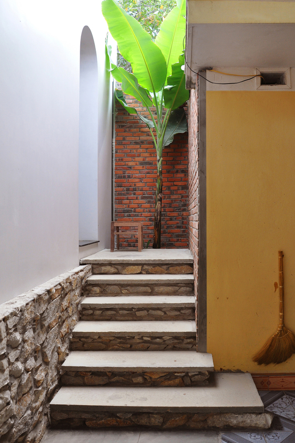 
Lối đi giữa căn nhà cũ và mới được thiết kế với mảng tường gạch mộc tạo cảm giác hòa quyện giữa 2 không gian 