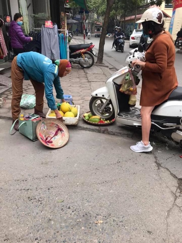  
Người phụ nữ mang bầu đi xe chèn lên nia hoa quả (Ảnh: V.T.T.P - KSĐP)