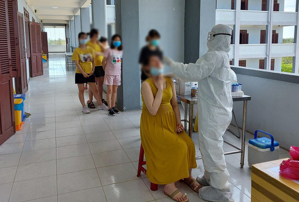  
Nhân viên y tế lấy mẫu xét nghiệm cho thai phụ từ Đài Loan về (Ảnh: Tiền Phong)
