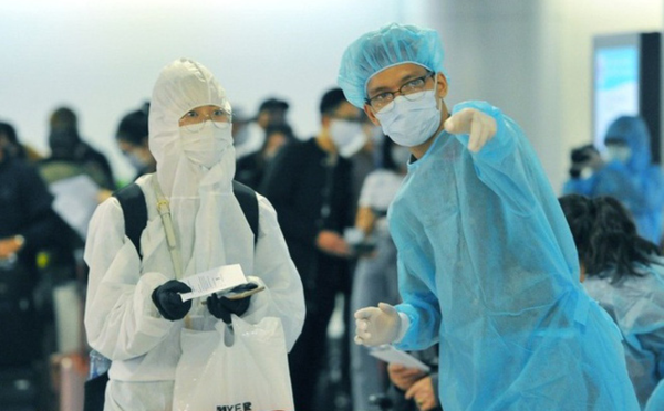  
Nhân viên y tế hướng dẫn mọi người làm thủ tục tại sân bay (Ảnh: Bộ Y tế)