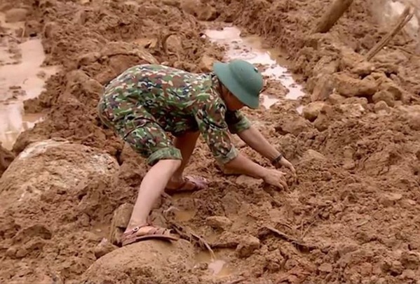  
Hình ảnh chiến sĩ công binh dùng tay không bốc bùn đất để tìm thi thể đồng đội (Ảnh: Thanh Niên)