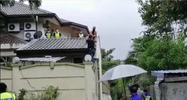  
Lực lượng cảnh sát đến bắt tên trộm trên nóc nhà. (Ảnh: Cắt từ clip)