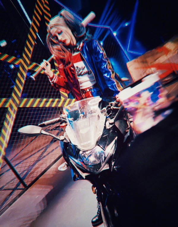  
Quan Hiểu Đồng lái mô tô và mang theo một chiếc dùi cui, tư thế và động tác của cô rất giống Harley Quinn. (Ảnh: Weibo)