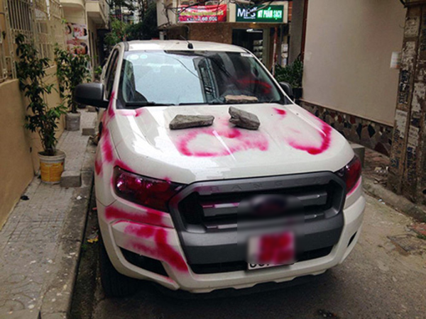      
Chiếc xe bị bôi sơn và chèn gạch vì chắn lối đi. (Ảnh: Người Lao Động)