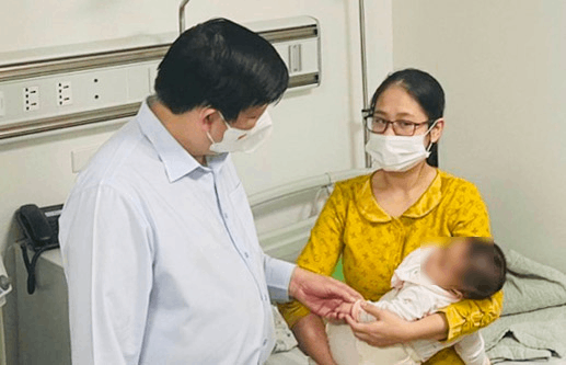  
Bộ trưởng Bộ Y tế thăm hỏi sức khỏe của một trẻ bị tiêm nhầm vaccine. (Ảnh: Hà Nội Mới)