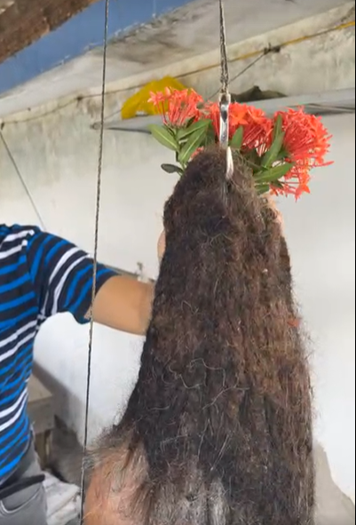    Mỗi lần ngồi thiền, chú Mười Đỉnh thường cài một loại hoa trên đều để thể hiện sự hướng Phật. (Ảnh: Chụp màn hình Độc lạ Bình Dương)