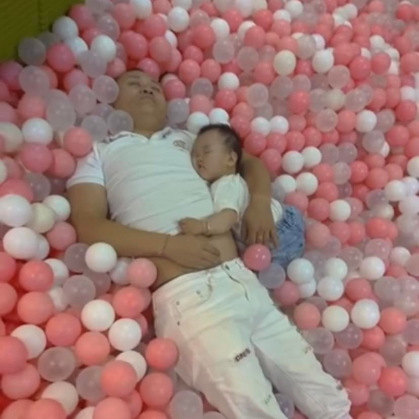 Hai bố con ôm nhau ngủ ngon lành trong nhà bóng (Ảnh: Weibo Việt Nam)