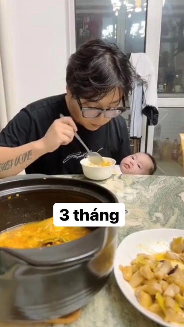  Đến ăn cơm ông bố trẻ cũng phải bế con trên tay. (Ảnh: Weibo)