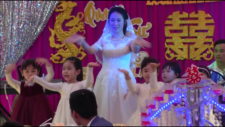 
Cô giáo xinh đẹp biểu diễn cùng học sinh trong ngày cưới của mình. (Ảnh: Cắt clip)