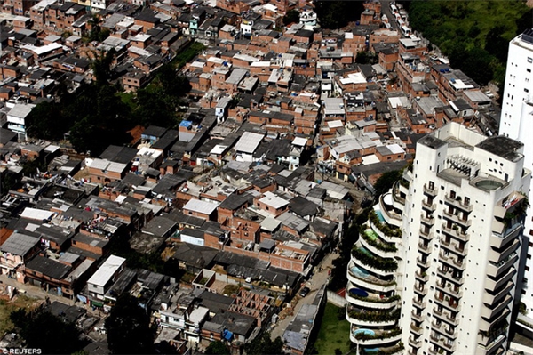 Khu ổ chuột Paraisopolis với 60.000 cư dân nằm sát ngay những căn hộ hiện đại có bể bơi tại Morumbi, Sao Paulo, Brazil.