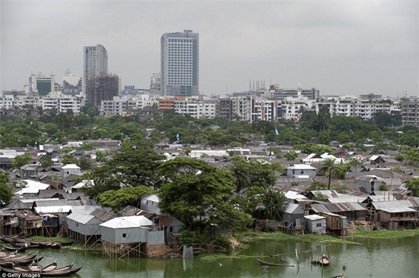 Phía sau khu vực dân cư nghèo khó ở sông Gulshan, Dhaka (Bangladesh) là cuộc sống phát triển hiện đại, nơi có những tòa nhà cao tầng.