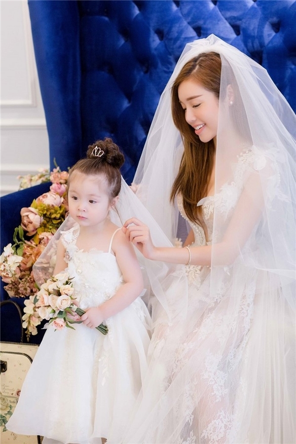 
Trong bộ ảnh được thực hiện vào đầu năm nay, Elly Trần và con gái lại khiến khán giả mê đắm khi diện váy cưới bồng xòe, trắng tinh khôi, thanh tú.