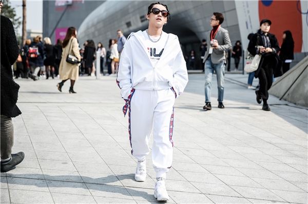 
Cụ thể, Sơn Tùng diện trang phục màu trắng mang đậm phong cách thể thao. Tổng thể là sự kết hợp của nhiều thương hiệu nổi tiếng như: Vetements, giày Reebook Classic, áo Gosha Rubchinsky và Fila, kính Versace.