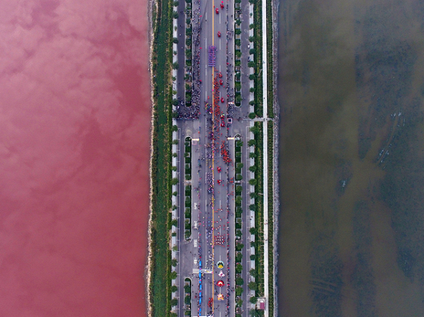 
Màu sắc tương phản giữa hồ muối được phân chia rõ ràng nhờ vào con đường đi xuyên ở giữa ở Vận Thành, Trung Quốc.