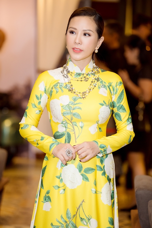 
Hoa hậu Thu Hoài duyên dáng, thanh lịch trong tà áo dài truyền thống với sắc vàng hoa cải kết hợp hoạ tiết hoa màu trắng to bản.