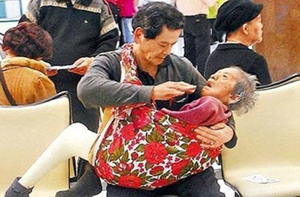 
Hình ảnh người đàn ông trung niên địu mẹ già đến bệnh viện chữa trị chân mỗi ngày, cũng đã từng lấy nước mắt của hàng triệu người trên thế giới. (Ảnh: Internet)
