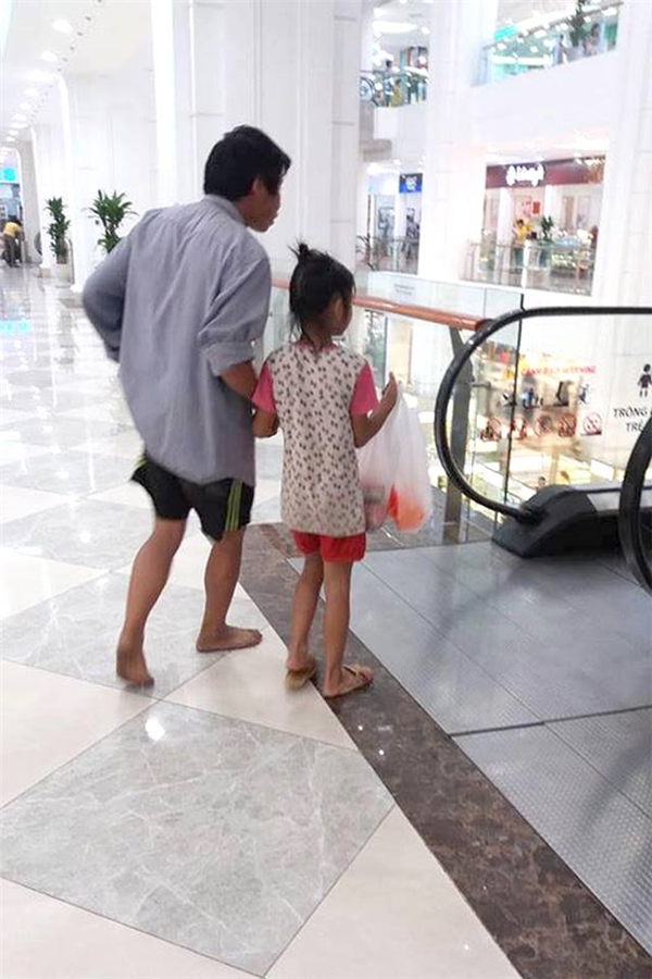Hai cha con đi mua sắm giữa trung tâm thương mại.