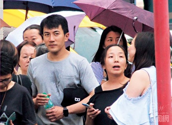 
Lưu Khải Uy trong trang phục giản dị đội mưa đến đón con gái.