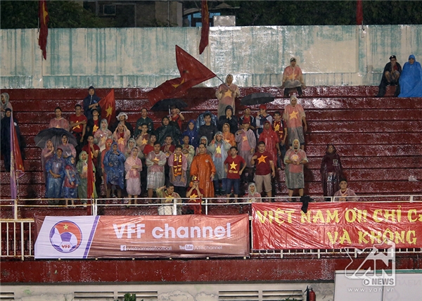 
Người hâm mộ đội mưa xem các cầu thủ U22 Việt Nam thi đấu.