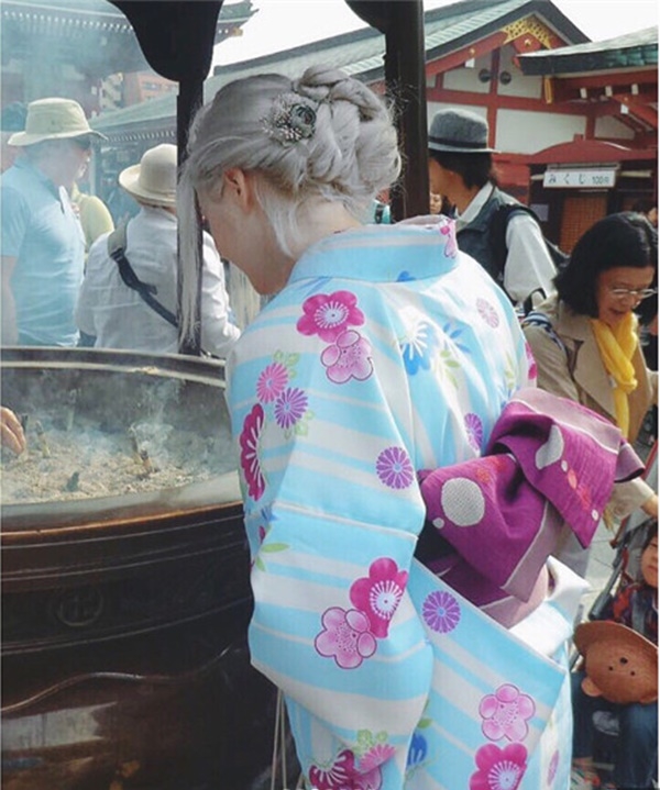 
Bức ảnh chụp sau lưng của cô gái có mái tóc bạch kim, diện kimono trên đường phố Nhật Bản.