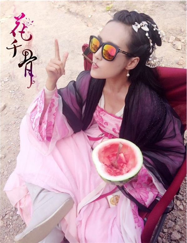 
"Ác nữ" Nghê Mạn Thiên (Lý Thuần) vừa đeo kính râm vừa ngồi ăn dưa hấu chờ tới cảnh quay.