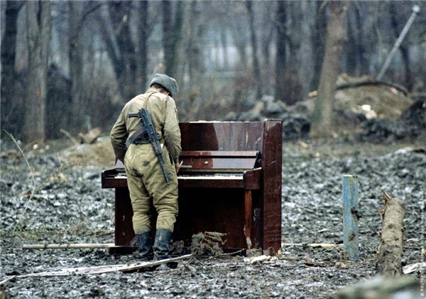 
Một người lính Nga đang chơi cây đàn piano bị bỏ lại tại bãi đất hoang. Cây súng và cây đàn, tàn khốc và đẹp đẽ, một bên tàn phá và một bên hàn gắn tâm hồn.