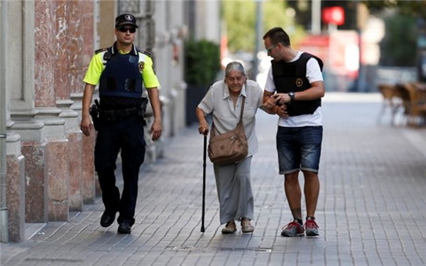 
Các nhân viên cảnh sát đang giúp một phụ nữ lớn tuổi thoát khỏi hiện trường ngày hôm qua (Ảnh: Getty)