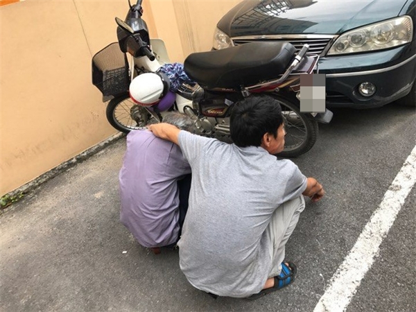 
Anh Nguyễn V.L., con trai bị cáo để bố ngồi nghỉ trước khi đưa ra xe ô tô đợi sẵn ngoài cổng TAND TP. Hà Nội.