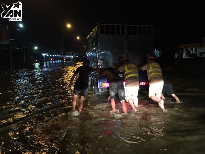 
Những chiếc xe ô tô và xe máy bị chết máy do ngập nước được cứu hộ khẩn cấp bằng cách dùng sức người đẩy xe ra khỏi vùng nguy hiểm.