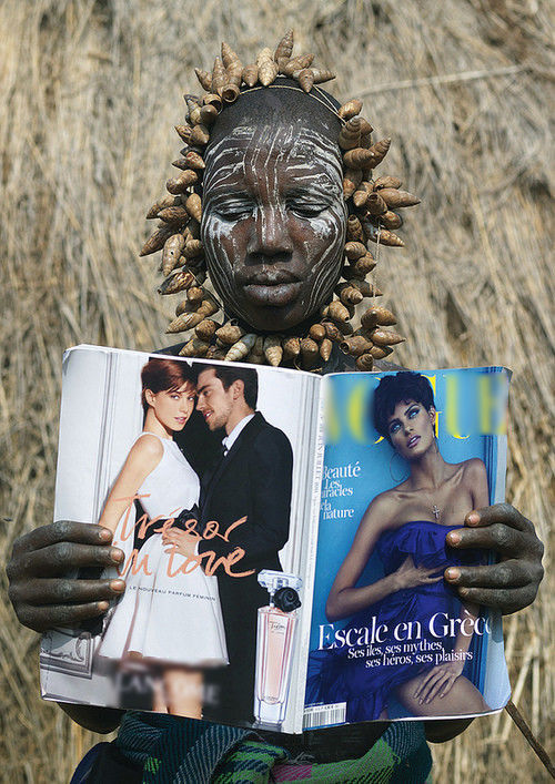 
Một cô gái trong bộ tộc Mursi tại Ethiopia đang lướt qua quyển tạp chí thời gian nổi tiếng thế giới