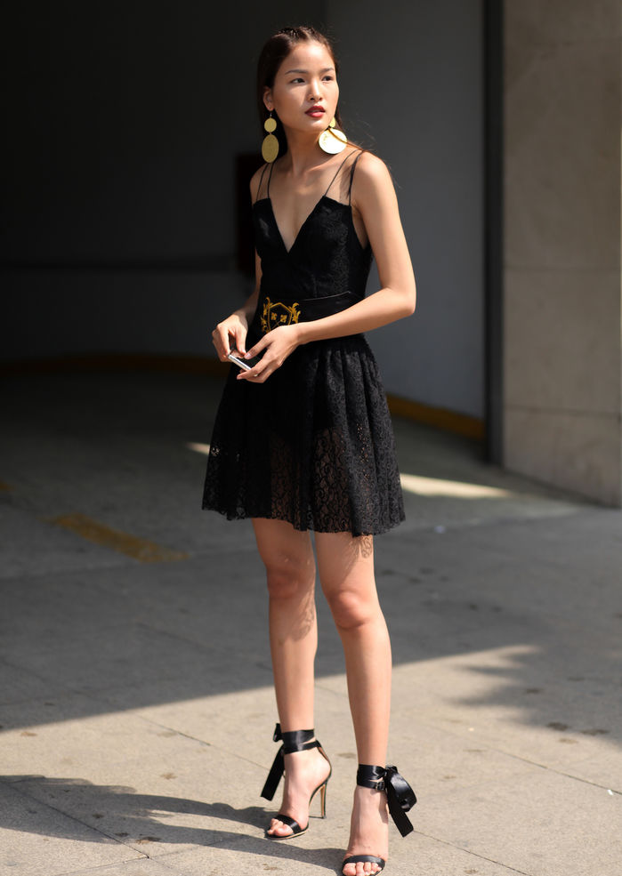 
Chà Mi – Top 3 Vietnam Next top Model 2017 sử dụng phụ kiện là một đôi khuyên ánh vàng cùng thắt lưng với hoạ tiết cam tô điểm cho bộ váy đen.