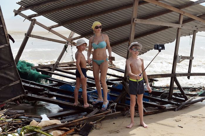 
Ba mẹ con du khách người Nga đang vui vẻ chụp ảnh bên xác của một cái nhà lồng của ngư dân Nha Trang bị trôi dạt vào bờ sau cơn bão. (Ảnh: Zing.vn)