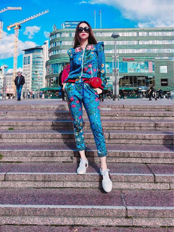 
Hình ảnh của Hà Hồ chụp tại Na Uy trong bộ tracksuit xanh dương đầy họa tiết nổi bật với túi đeo ngang hông và giày sneaker kẻ sọc đình đám của một nhà mốt nổi tiếng.