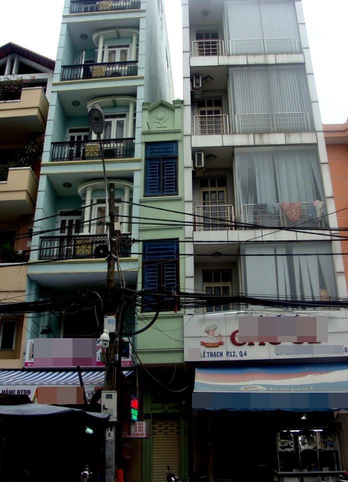 
Ngôi nhà số 9 Lê Thạch (màu xanh lá cây) chiều ngang 80 cm, nằm "bẹp dí" giữa khe hở của 2 nhà hàng xóm cao tầng. (Ảnh: Người Việt)