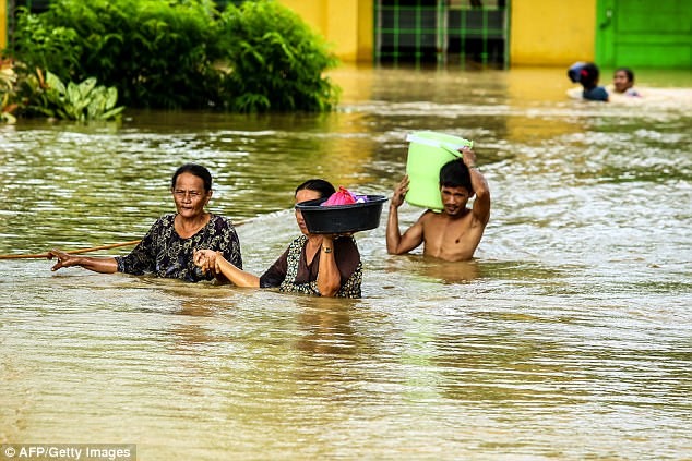 
Người dân ở Kabacan, Bắc Cotabato, và miền Nam của đảo Mindanao lội qua dòng lũ để sơ tán đến nơi an toàn hơn