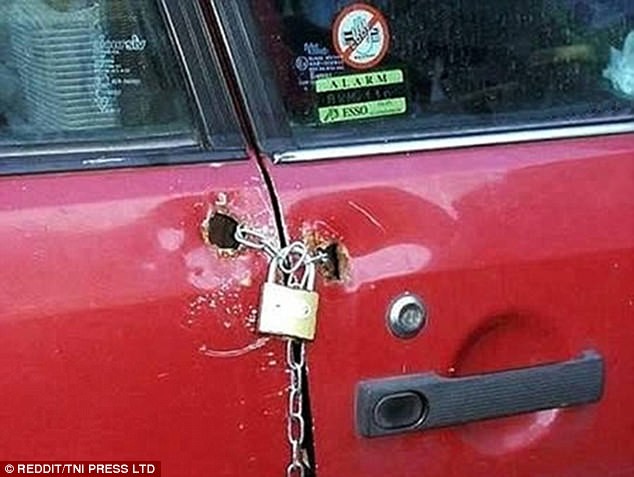 
Chủ sở hữu của chiếc xe màu đỏ này đã sử dụng ngay dây xích và một chiếc khóa hết sức quen thuộc để khóa chiếc xe của mình lại. Người này thậm chí còn đục hẳn 2 lỗ ở trên 2 cánh cửa để làm nơi luồn dây khóa qua.