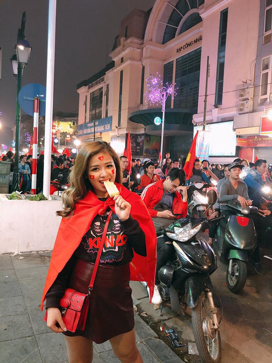 
Dương Hoàng Yến với chiếc sweatshirt hoạ tiết phối chân váy da ngắn và khoác trên mình lá cờ đỏ.