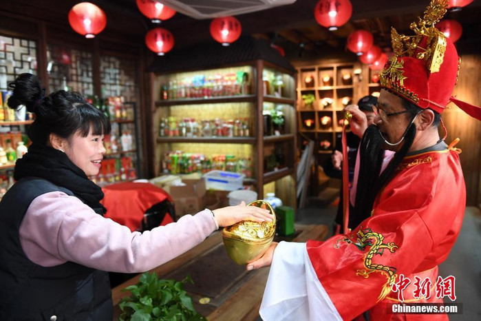 
Một chủ cửa hàng tại Chiết Giang đang sờ vào thỏi vàng của "Thần Tài" để lấy may trong năm mới