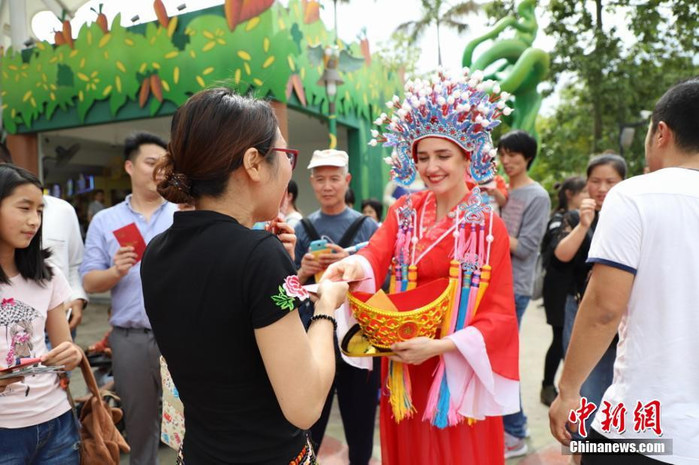 
Tại Quảng Châu, tỉnh Quảng Đông, một người phụ nữ đóng giả thành Thần Tài để đi phát lì xì cho người dân trong vùng và chúc họ những lời chúc may mắn